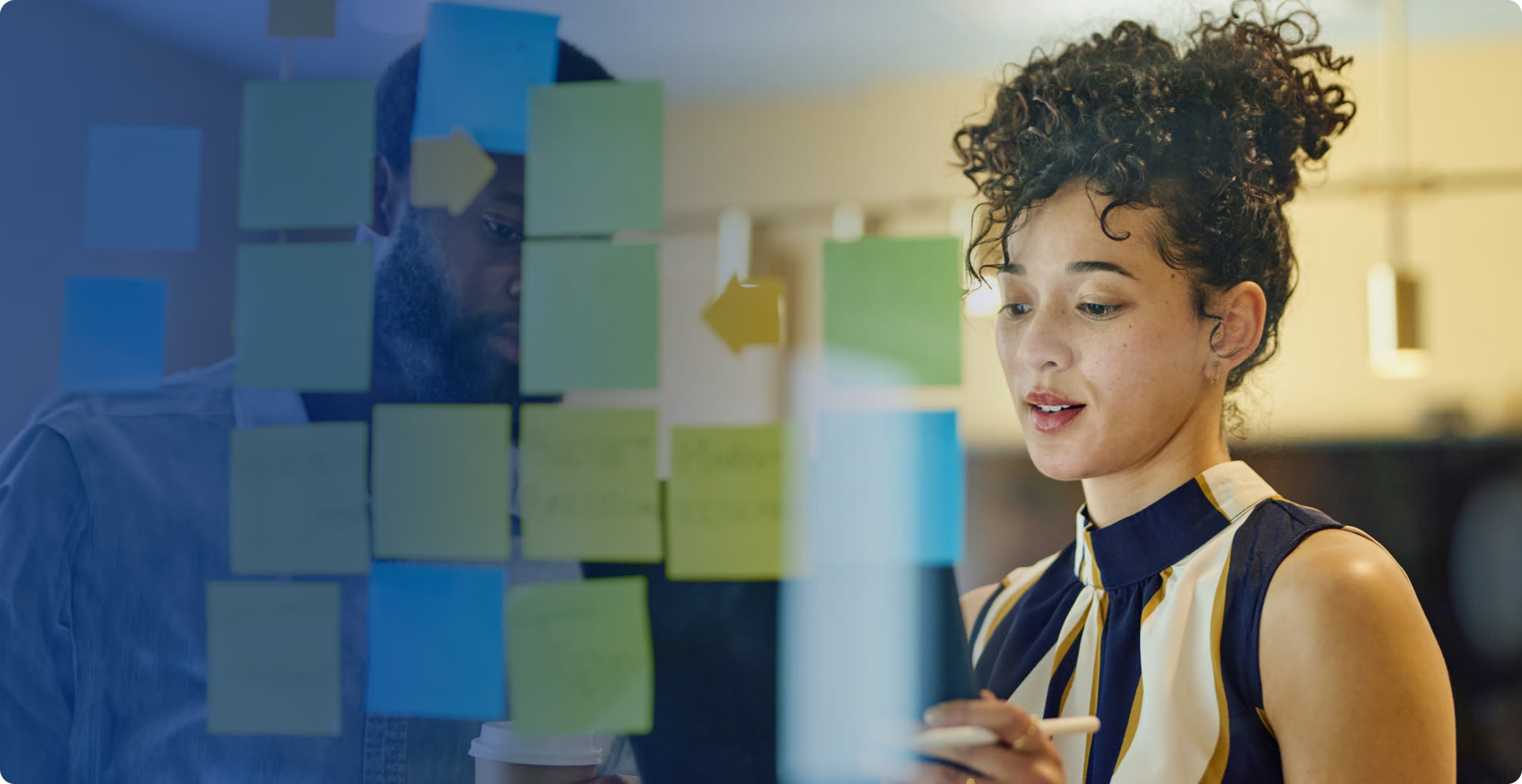 Instructor working through sticky notes on a glass wall