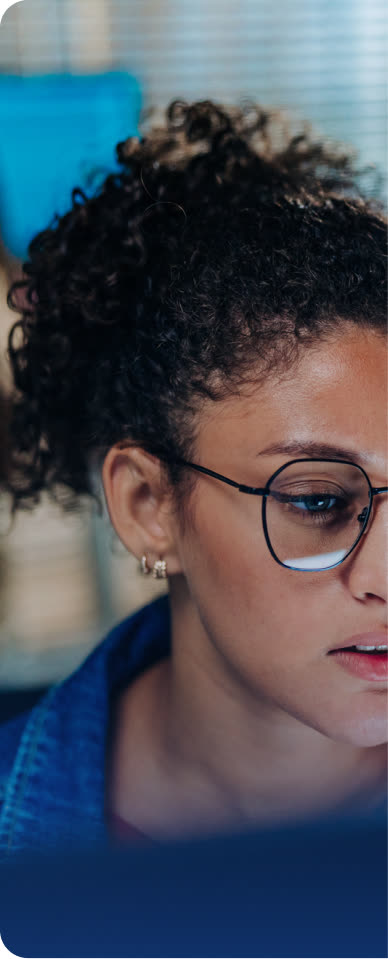 Analyst in glasses reviewing data on screen