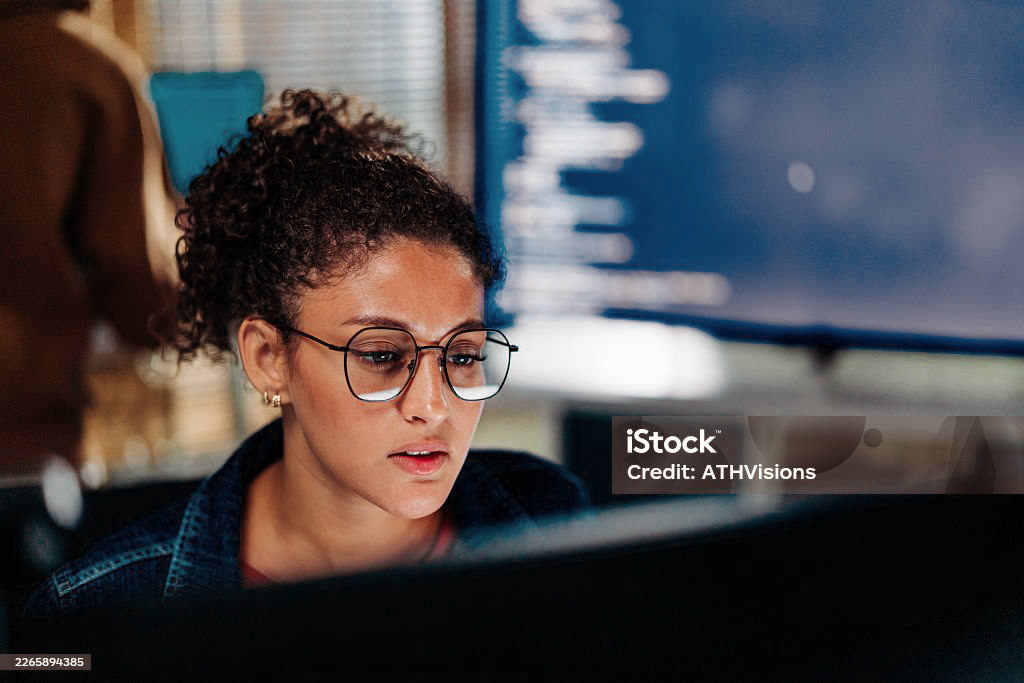 Engineer reviewing code across dual monitors