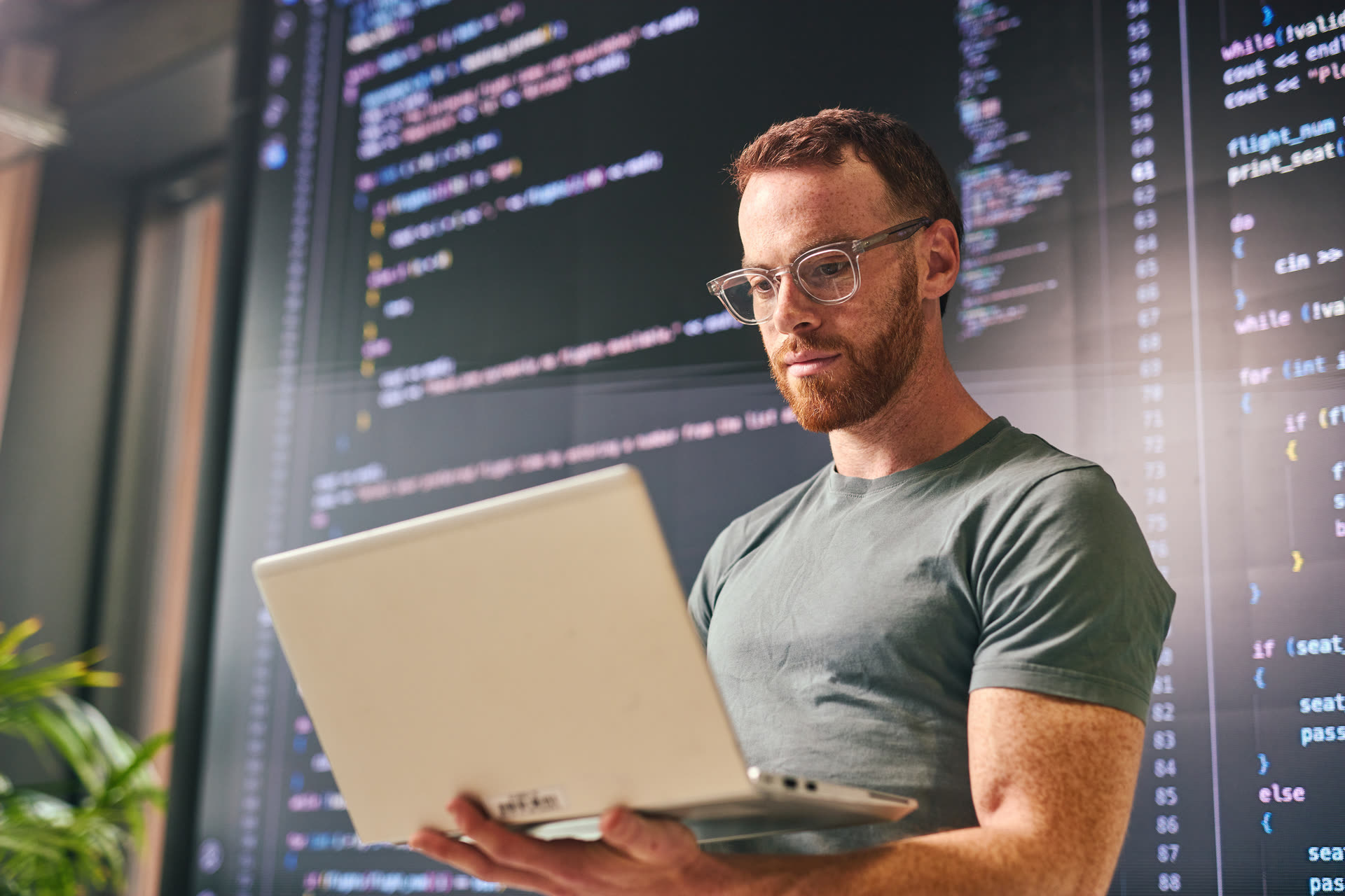 Instructor working on a laptop in front of code displays